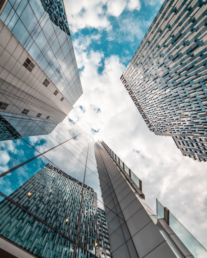 Home Low angle view of modern skyscrapers reflecting the cloudy sky in Brussels, Belgium.
