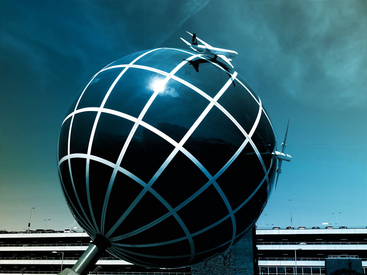 About Large spherical structure with airplane models against a clear sky.